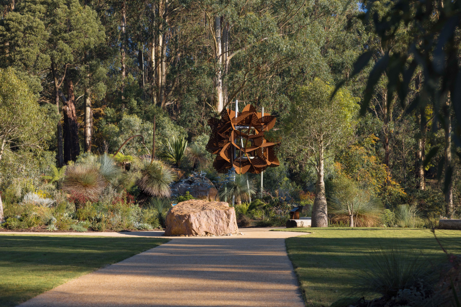 Concrete footpath leading towards large feature sculpture.