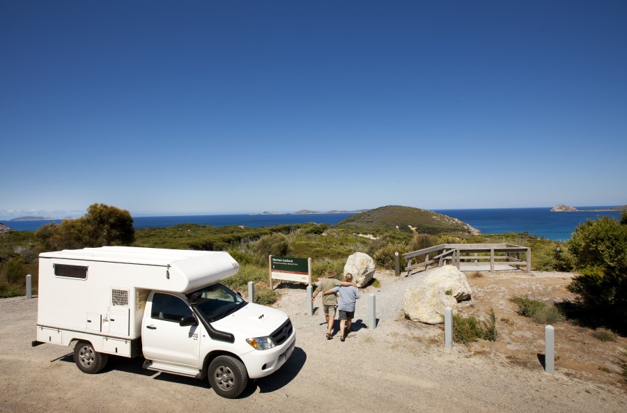 Caravan parked by beach entry with couple walking towards beach.Caravan parked by beach entry with couple walking towards beach.