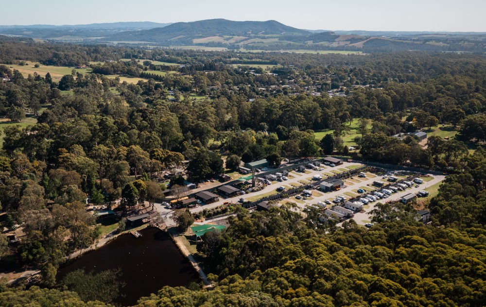 Aerial view of caravan park surrounded by forestry.